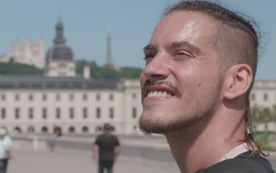 Thomas, un jeune homme en t-shirt noire, fait du vélo adapté sur les bords du Rhône à Lyon