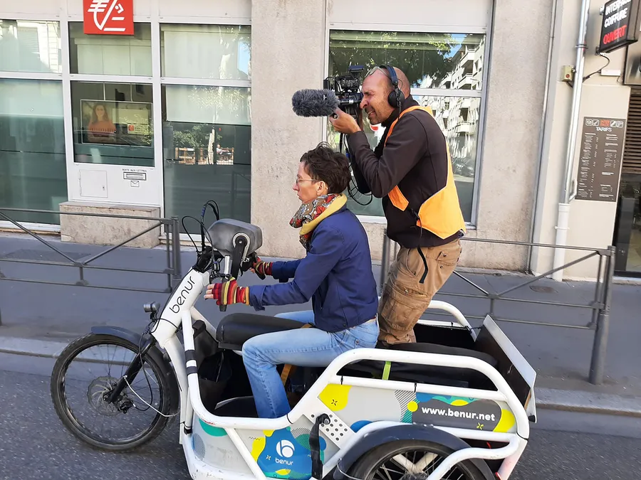Camille et Marc sont dans la rue. Ils filment depuis un triporteur